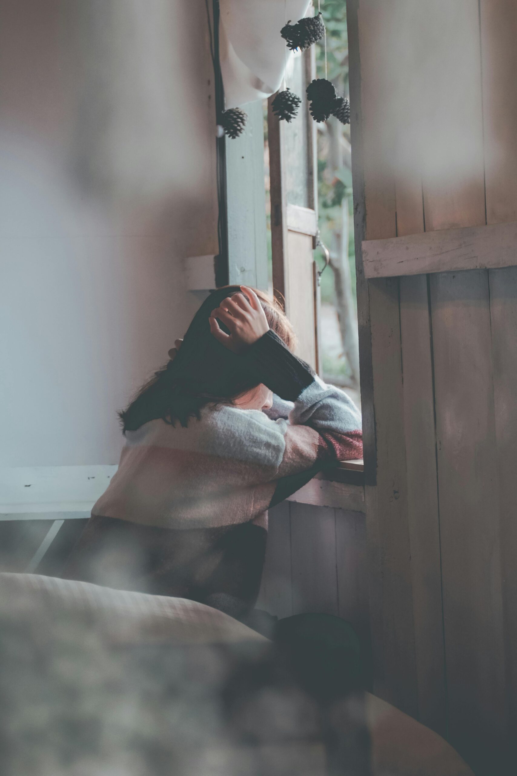 Depressed woman looking out window
